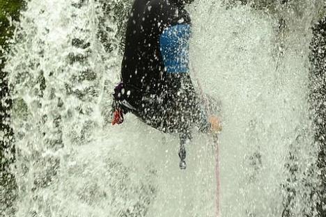a man standing beside a waterfall