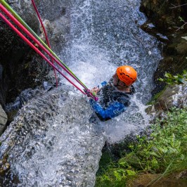 A person abseiling with water on top of them