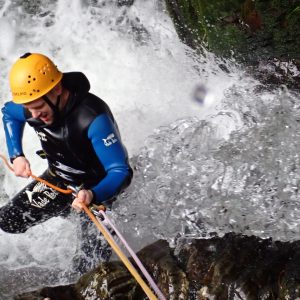 a man abseiling down a waterfall