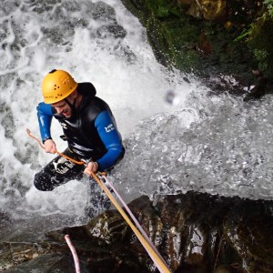 a man abseiling down a waterfall