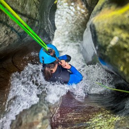 A woman holding on as she slides into the canyon