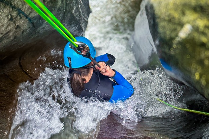 A woman holding on as she slides into the canyon