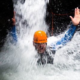 A man testing the power of the waterfall