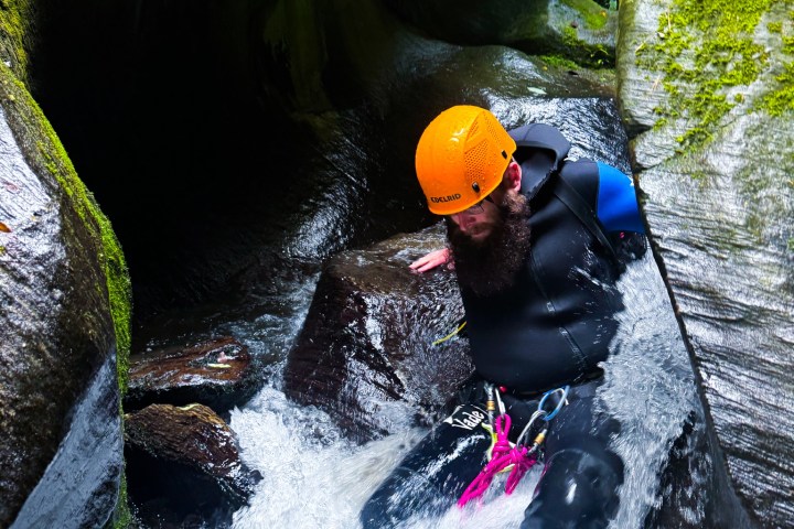 a person climbing through the canyon