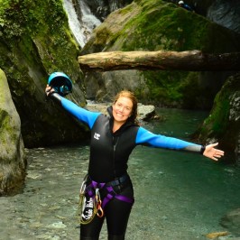 a person in a wet suit standing on a rock
