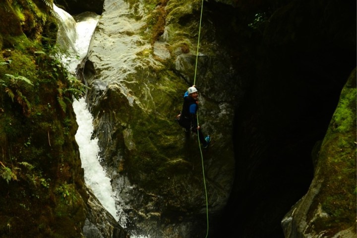 a man standing next to a waterfall