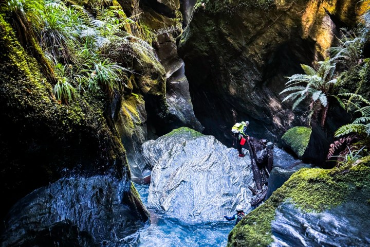 a large waterfall next to a rock