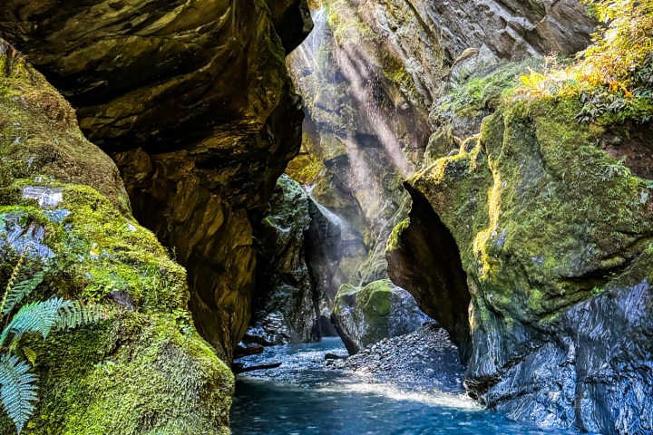 a large waterfall next to a rock