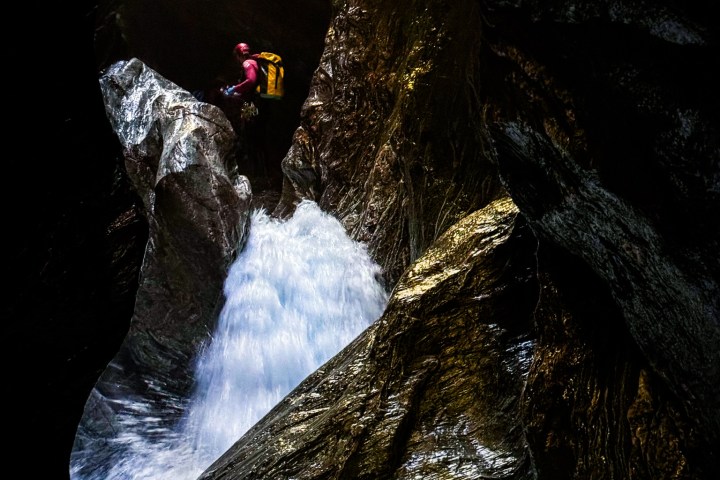 a man standing next to a waterfall