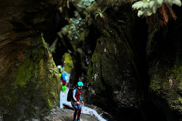 a man walking next to a waterfall