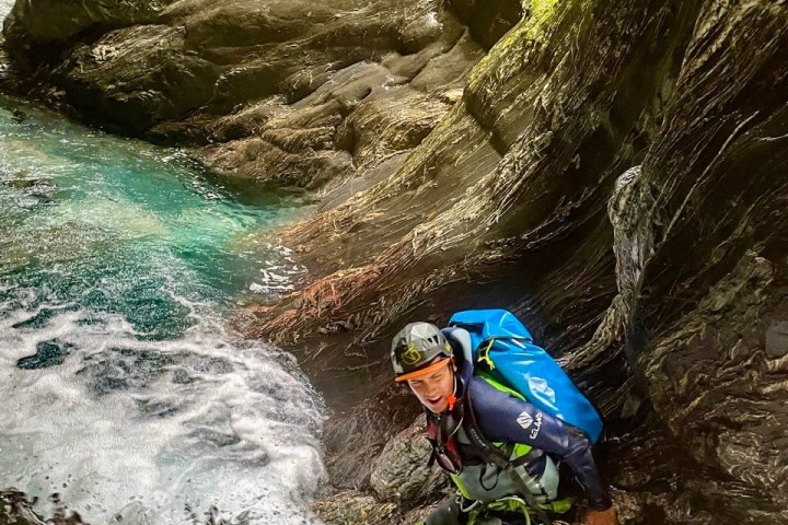 a person riding a wave on top of a rock
