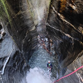A person standing at the bottom of the waterfall