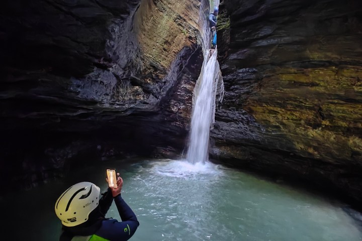 a man standing next to a waterfall