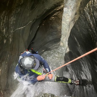 a man riding skis down a river next to a body of water