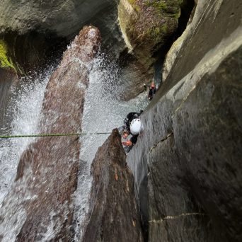 a large waterfall next to a rock wall