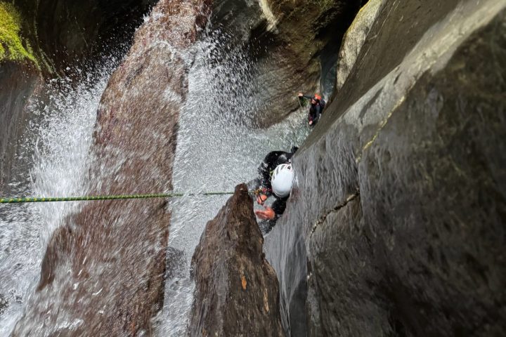 a large waterfall next to a rock wall