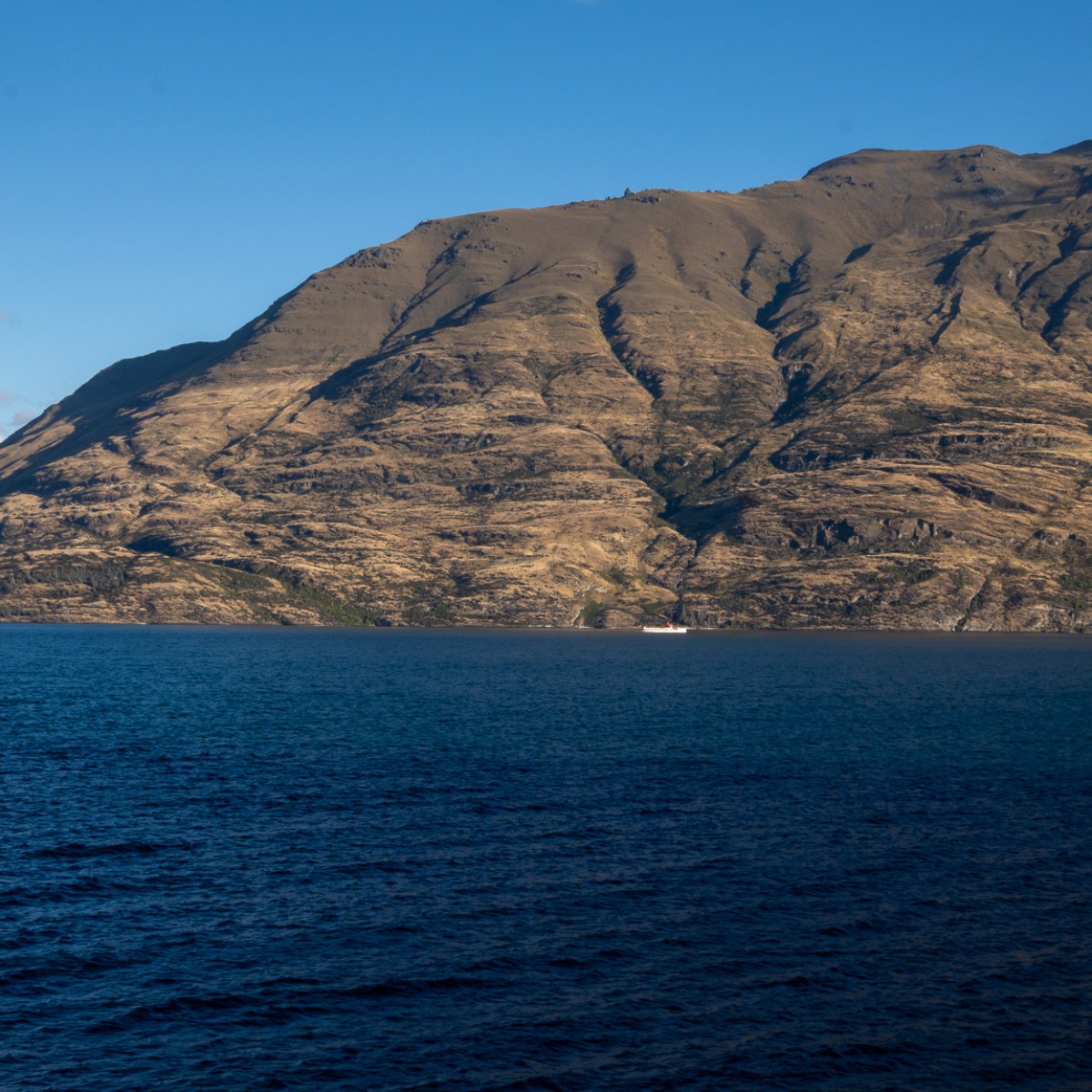Mountain landscape with a lake under a clear blue sky.